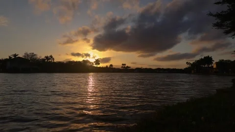 Timelapse of the sun setting behind homes across a lake Stock Footage 263849431
