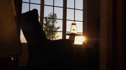 Timelapse of sun setting at home, empty chair facing out the window, sunset