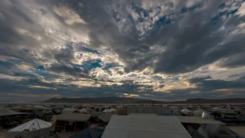Timelapse the sun in setting over campers and tents at a desert festival 스톡 동영상 228011387