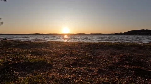 Timelapse of sun setting over the lake windy day waves rolling on the shore line Stock Footage 211066637