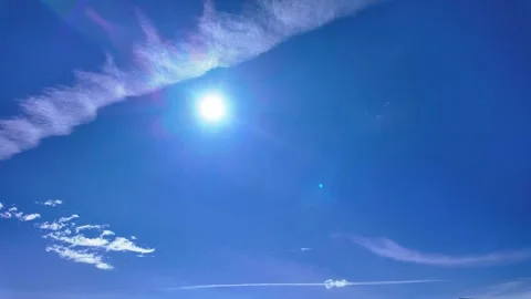 A timelapse of the sun shining through a beautiful blue sky with white clouds Stock Footage 285468635