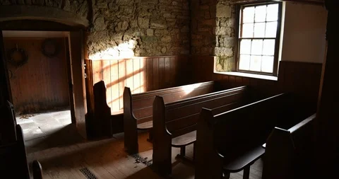 Timelapse of sun shining through old church window onto pews Stock Footage 96082160