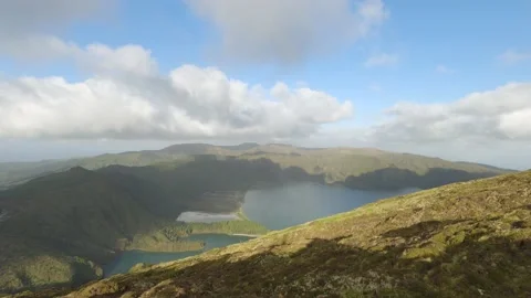 Timelapse of a sunny day with clouds and a lake surrounded by green meadows. Stock Footage 203166732