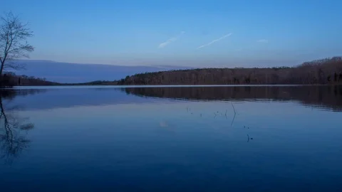 Timelapse of sunrise and clouds over reflective lake	 Stock Footage 99269669