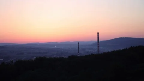 Timelapse of sunrise over a small town with a factory in the valley. Stock Footage 79716788