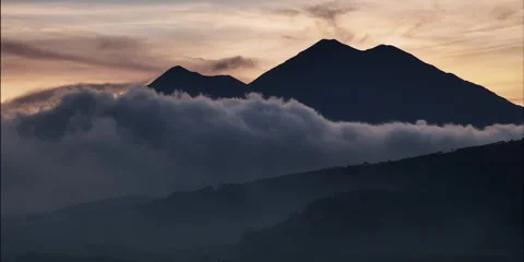 Timelapse of sunset behind two volcanoes Video stock 255410033