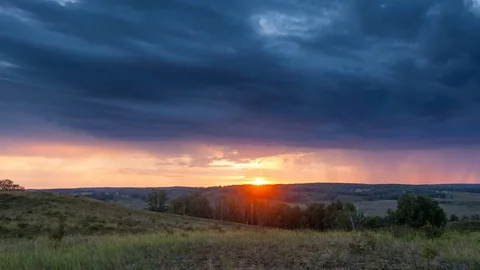TIMELAPSE: Sunset in a hilly valley, the approach of dusk. Silhouette of rain Video stock 84426559