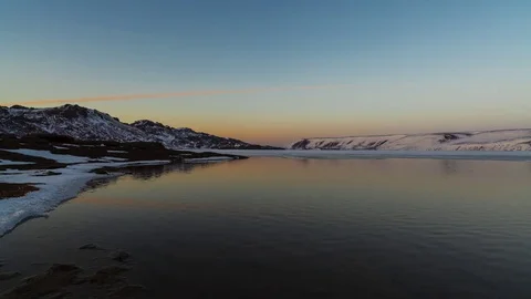 Timelapse of sunset at lake surrounded with snow covered mountains Stock Footage 73011796