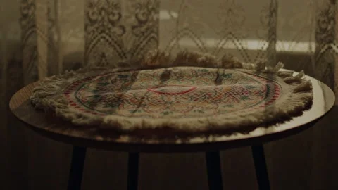 Timelapse of sunset light and shadows moving across embroidered doily on woo Vidéo 346305548