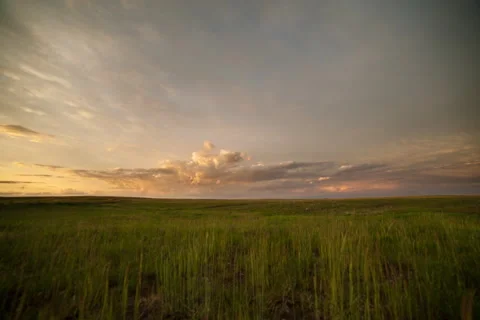 Timelapse of sunset lighting clouds over grassland prairie Stock Footage 62057402