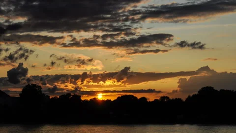 Timelapse of sunset with moving clouds and silhoette of trees in germany Stock Footage 249807731