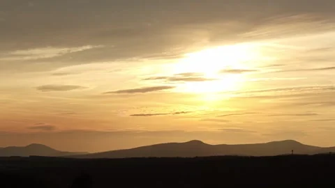 Timelapse of sunset with moving clouds and mountains in the background 스톡 동영상 270773644