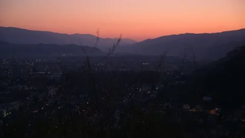 Timelapse sunset with orange sky, looke down from the hill on small moving light Stock Footage 132304671