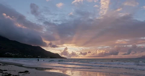 Timelapse: Sunset over beach, orange clouds and swimmers bathing in sea Stock Footage 236541760
