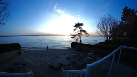 Timelapse of sunset over blue calm water Stock Footage