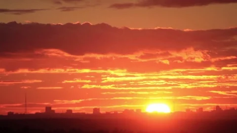 Timelapse of sunset over city with clouds in the sky and orange teal tones. Stock Footage 77436481