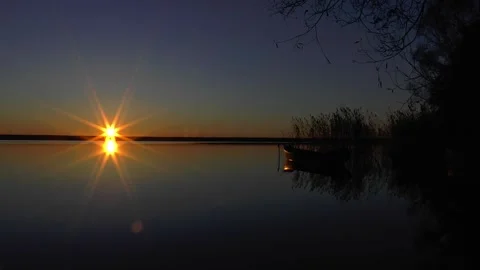 Timelapse of sunset over the lake. calm. fall. boat in the reeds Stock Footage 289042235