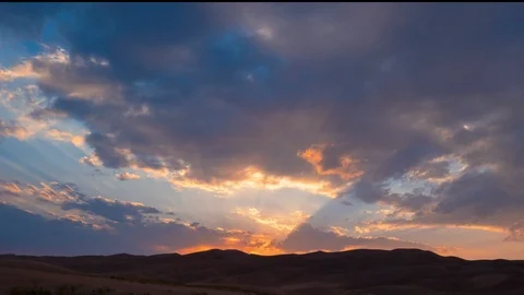 Timelapse of Sunset over Sand Dunes with Beautiful Clouds and Sun Rays Stock Footage 111215807