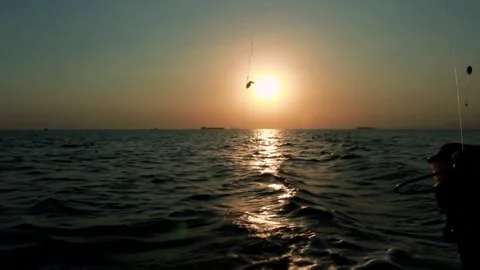 Timelapse of a sunset over the sea while fishing from a boat Stock Footage 312038213