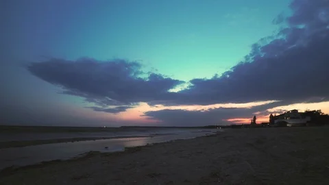 Timelapse: Sunset reflected on wet beach sand with incoming ocean waves and Stock Footage 117341332