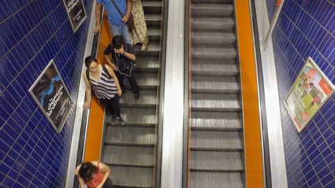 Timelapse of top view of crowd of people going up and down on a escalator Stock Footage 107491058
