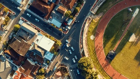 Timelapse Top View of Stadium Jogging Track Beside Busy Intersection Road Stock Footage 105770799