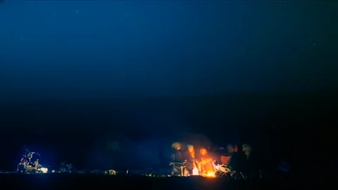 Timelapse of tourists group by the campfire of camp under the night starry sky Stock Footage 179079402