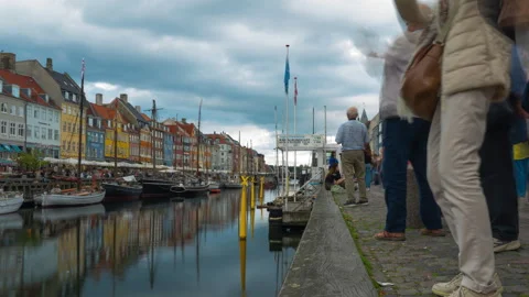 Timelapse of tourists walking and taking photos along the historic Nyhavn canal Stock Footage 345446544