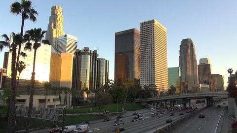 Timelapse traffic car on freeway at sunset Los Angeles business area tall tower Stock Footage 87612226