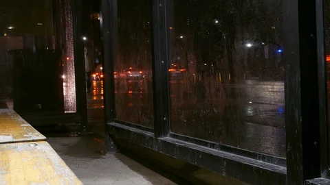 Timelapse of traffic going by as seen from a bus stop on rainy evening Stock Footage 88262211