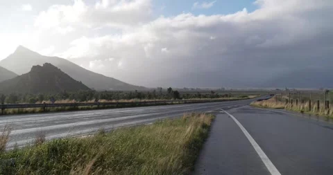 Timelapse of traffic passing with clouds over mountains Stock Footage 277389971