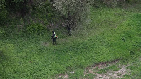 Timelapse: two men mow grass with trimmers Video stock 135729991