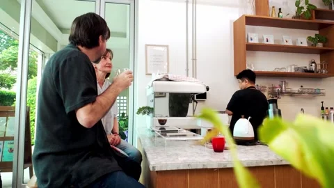 Timelapse of two middle-aged customers enjoy fresh coffee and conversation. Stock-Footage 312686950