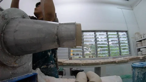 Timelapse of two workers making piles of clay with mechanic machine, Malaysia Stock Footage 146550499