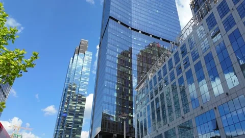Timelapse of urban skyscraper reflections and blue sky with moving clouds. Stock Footage 331533197
