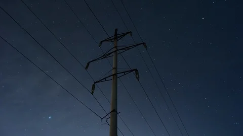 Timelapse: Utility pole and high voltage power transmission line at night Stock Footage 118744244