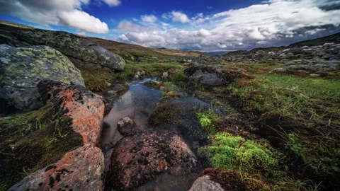 A timelapse video captures the reflection of stormy clouds and the barren Stock Footage 270036609