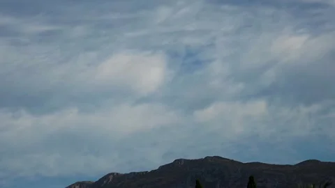 Timelapse video of dramatic clouds moving fast over Montgo mountain ridge in Stock Footage 345808204