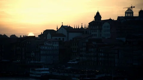 Timelapse video of large orange sun setting behind the Porto old town buildings Stock Footage 103444370