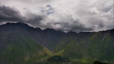 Timelapse video of mountains, valleys and fluffy clouds above them. Stock Footage 106087410