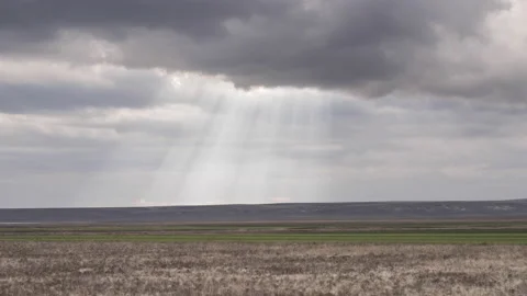 Timelapse Video of Ray of Lights Between Clouds Falling Down on a Landscape Stock Footage 133659363