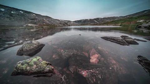 A timelapse video of a shallow pond with transparent water and a rocky Stock Footage 270074509