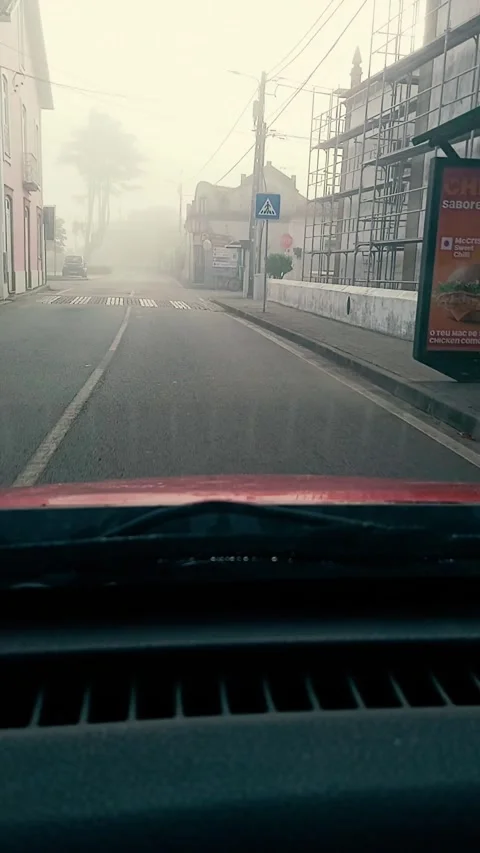 Timelapse view from a moving car driving through a small foggy Portuguese town Stock Footage 317950122