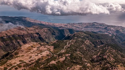 Timelapse with a view over the mountains from cloud height, overlooking a city. Stock Footage 301382720