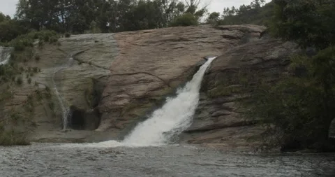 Timelapse of a waterfall in a river in a mountainous landscape on a blue sky day Stock Footage 133895486