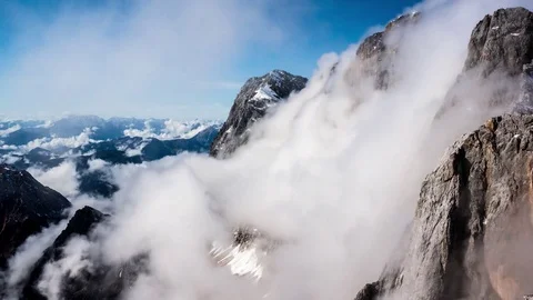 Timelapse of white clouds covering the rocky mountains Stock Footage 77815004