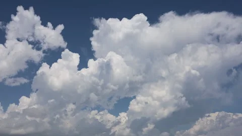 Timelapse of White Clouds Drifting Across a Clear Blue Sky Stock Footage 344734903