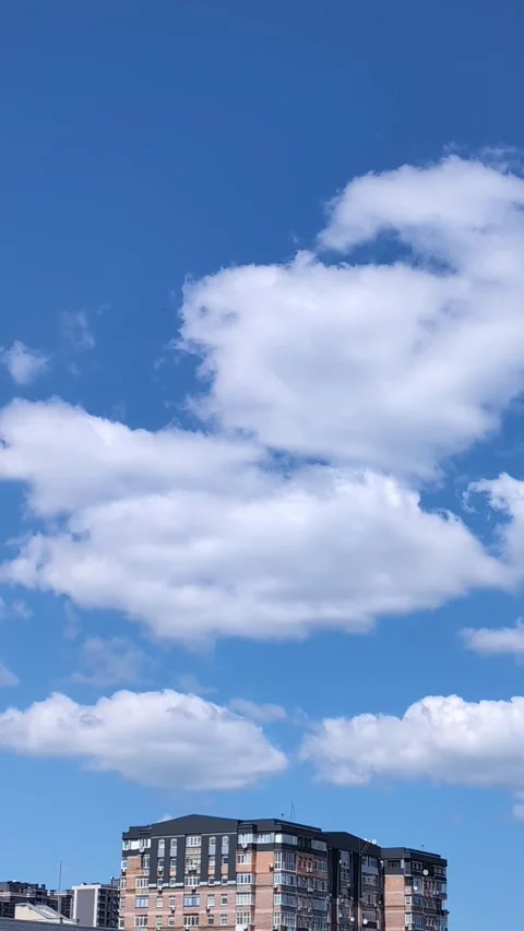 Timelapse of White Clouds Drifting Over City Residential Buildings Against .. Video stock 341949420