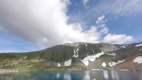 TimeLapse white clouds float across the sky over a mountain lake 動画素材 119530969