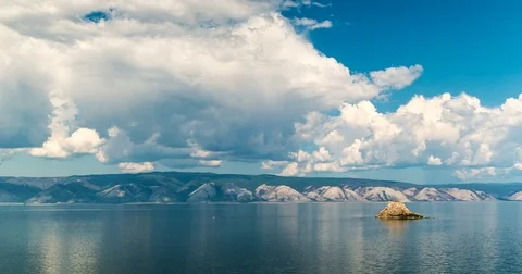 Timelapse. White clouds moving above the smooth lake. Stock Footage 78777974